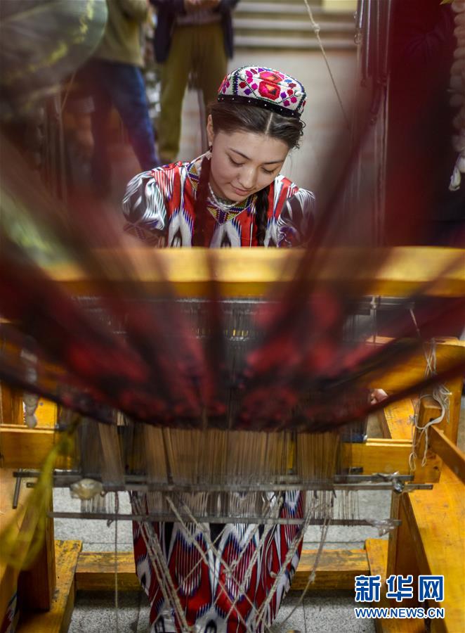 在位于乌鲁木齐市的新疆国际大巴扎内,店主麦迪娜在现场制作艾德莱斯绸(2017年4月24日摄)。